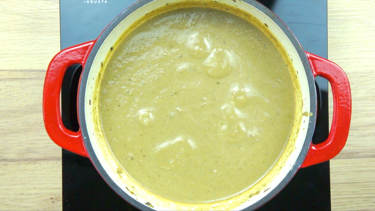 Red-white enameled Dutch oven with a thick cream of mushroom soup
