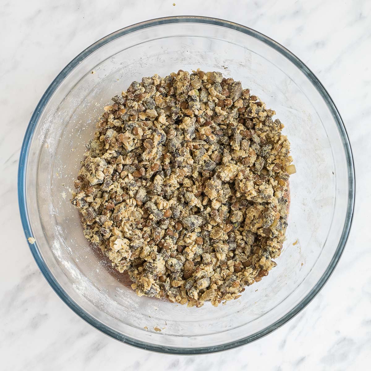 A lentil patty dough in a glass bowl.