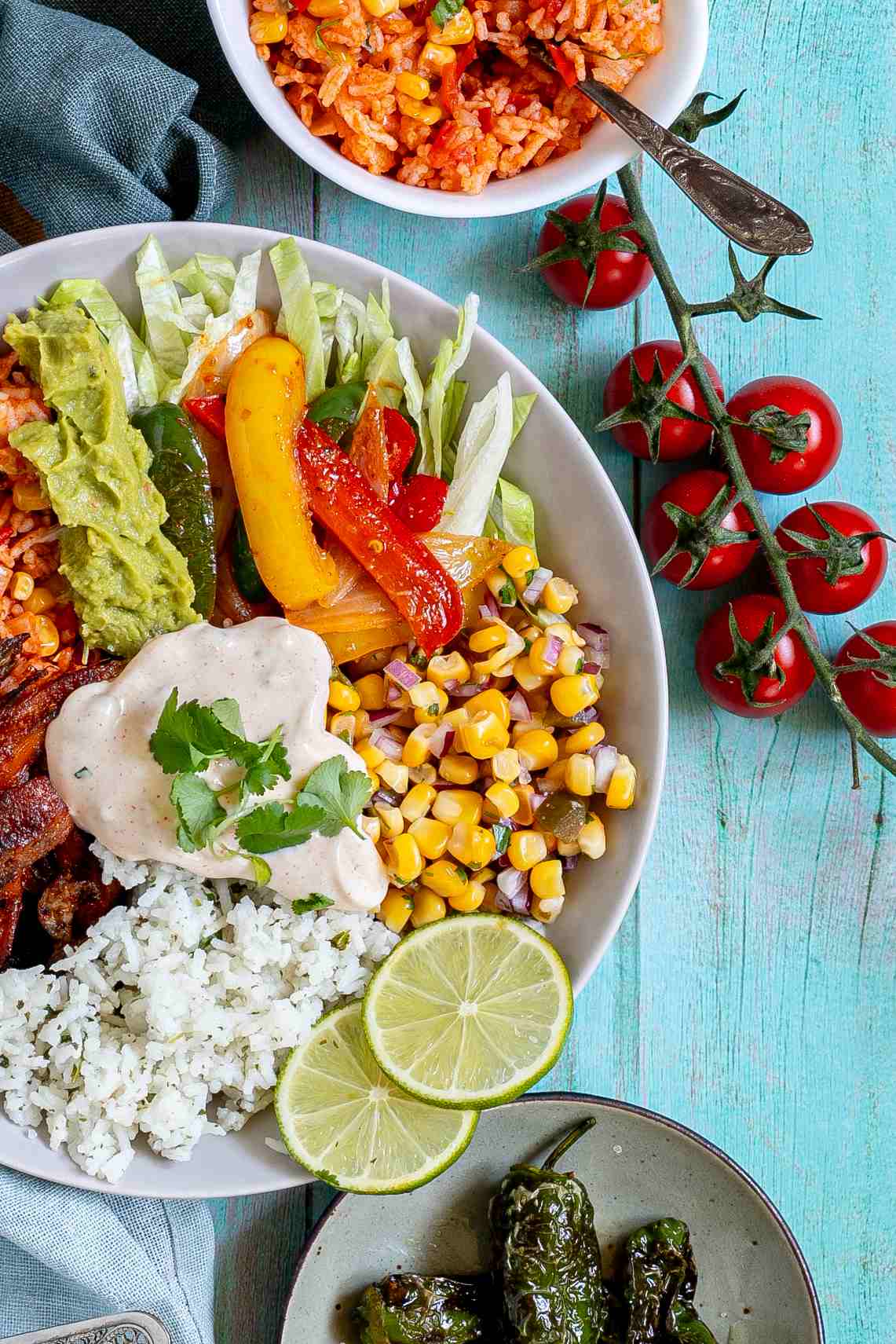 White bowl with cilantro lime rice, corn salsa, mushroom fajitas, guacamole, fajitas veggies and chipotle mayo.