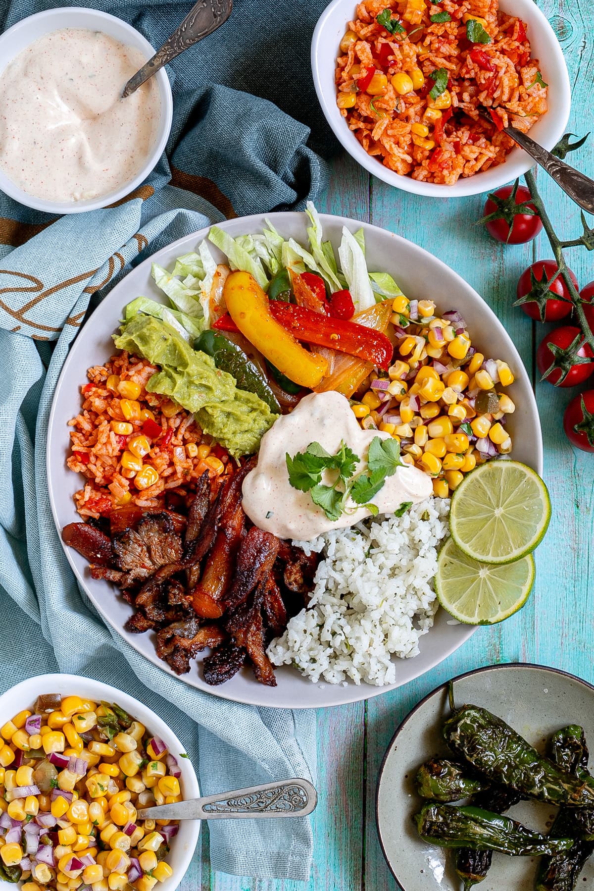 White bowl with cilantro lime rice, corn salsa, mushroom fajitas, guacamole, fajitas veggies and chipotle mayo.