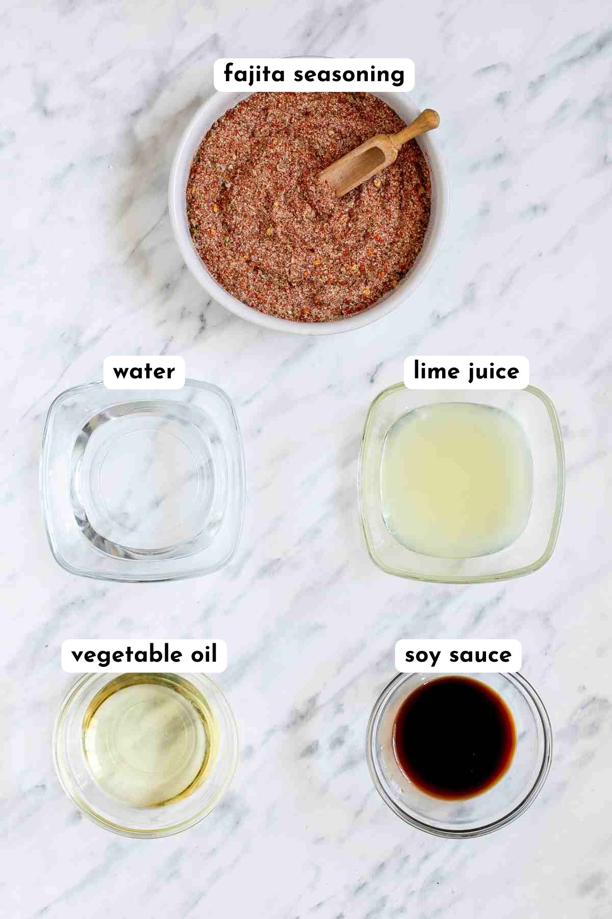 Ingredients of fajita sauce in small bowls, fajita spice mix, lime juice, oil, water, and soy sauce