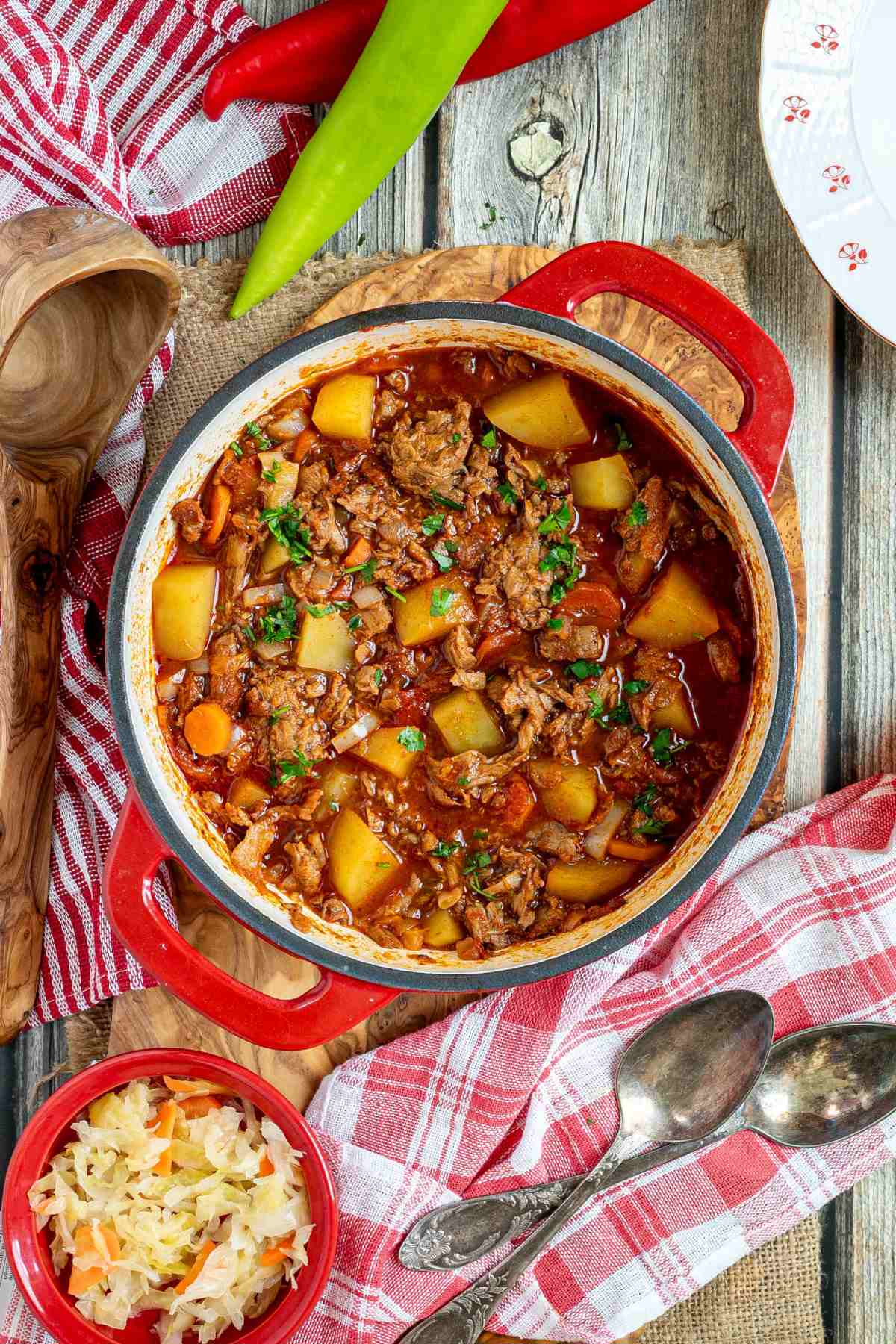 A pot of authentic Hungarian Goulash with meat and vegetables on a wooden table.
