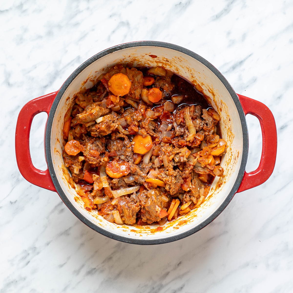 Cooked meat and vegetable mixture in a Dutch oven to make Hungarian Goulash.