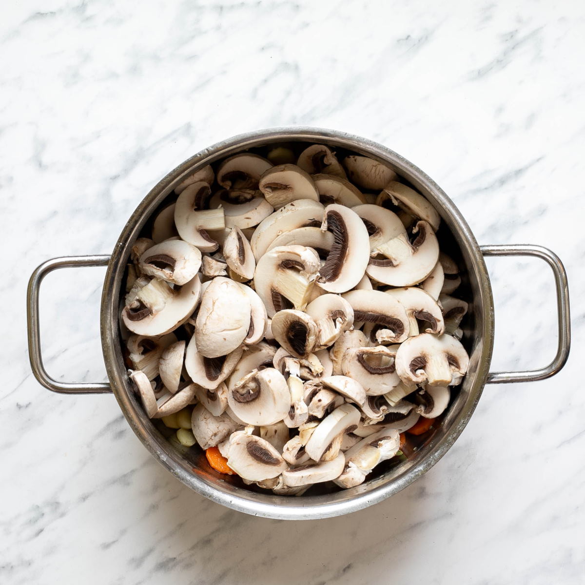 Chopped mushrooms in a stock pot to make Hungarian mushroom soup.