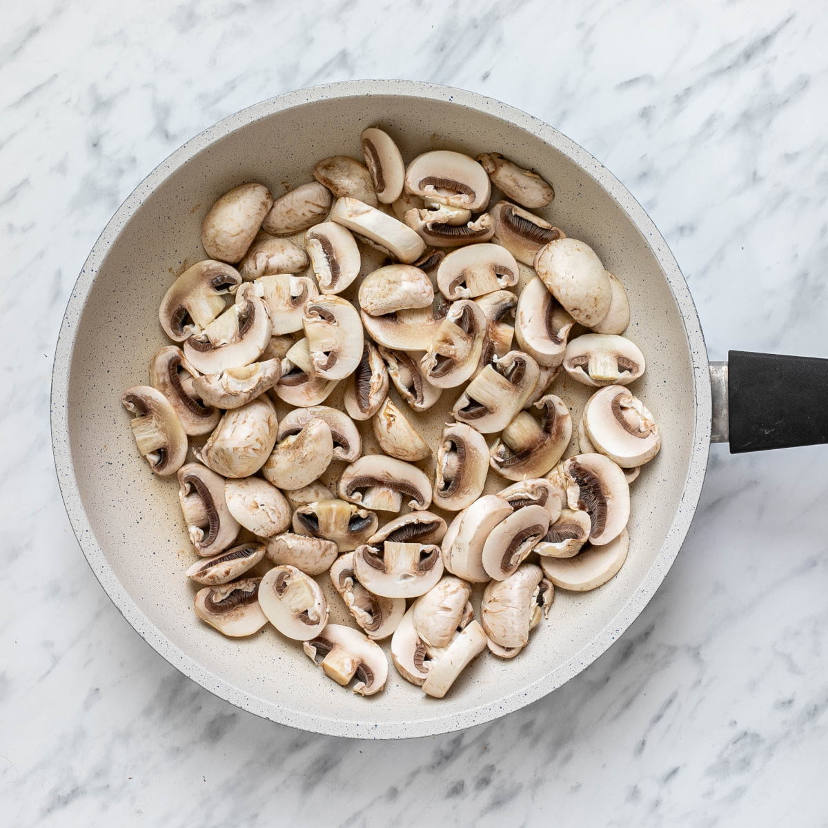 Sliced mushrooms in white pan