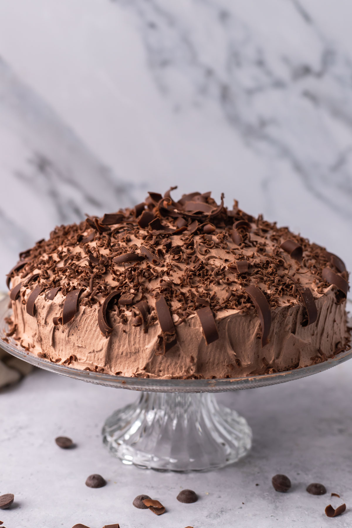 A chocolate cake covered with pieces of chocolate