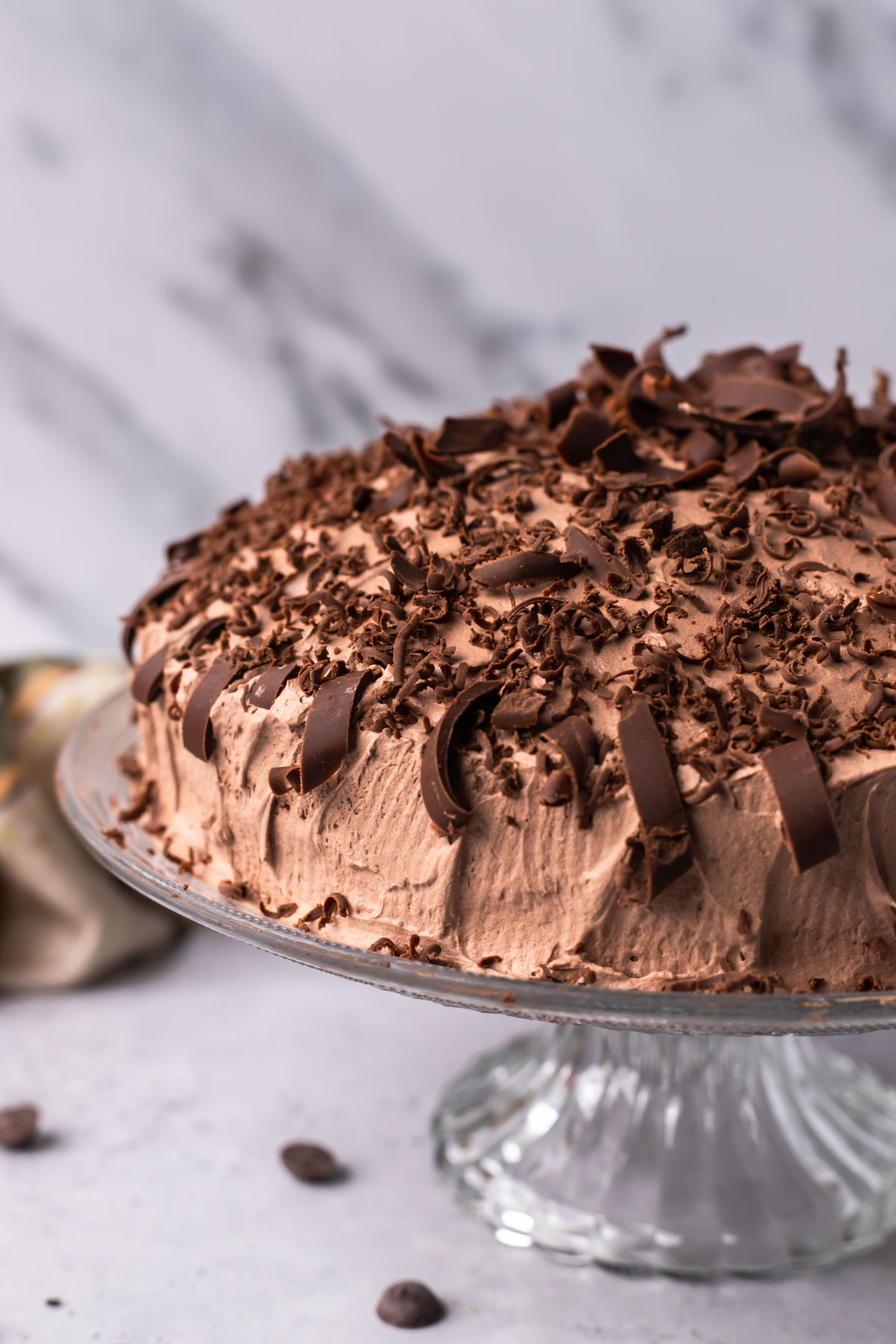 A chocolate cake covered with pieces of chocolate