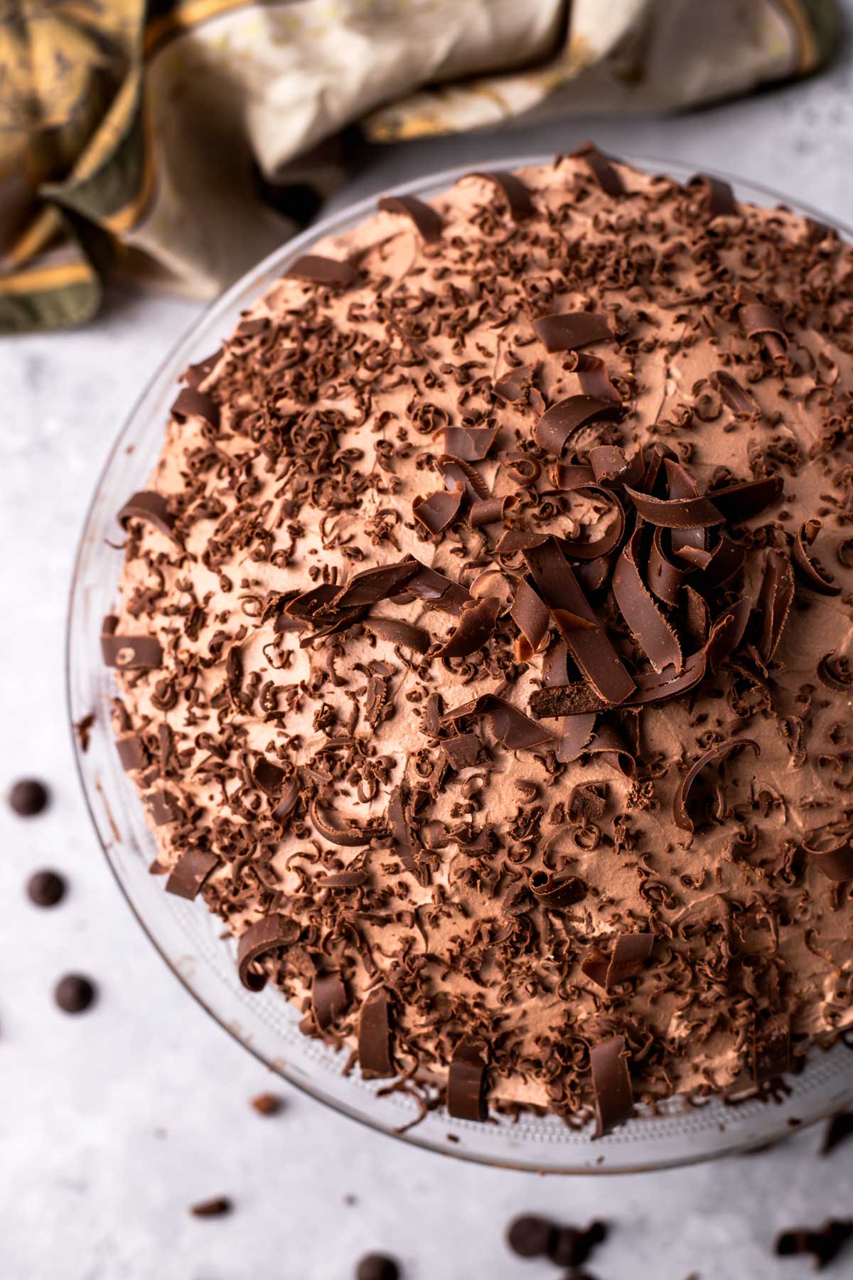 A chocolate cake covered with pieces of chocolate