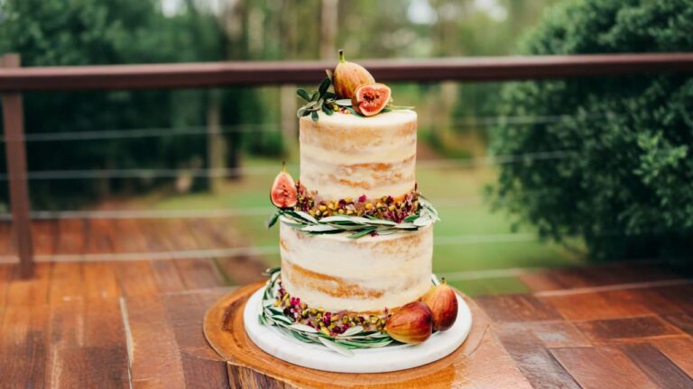 a three tiered cake with figs on top of it