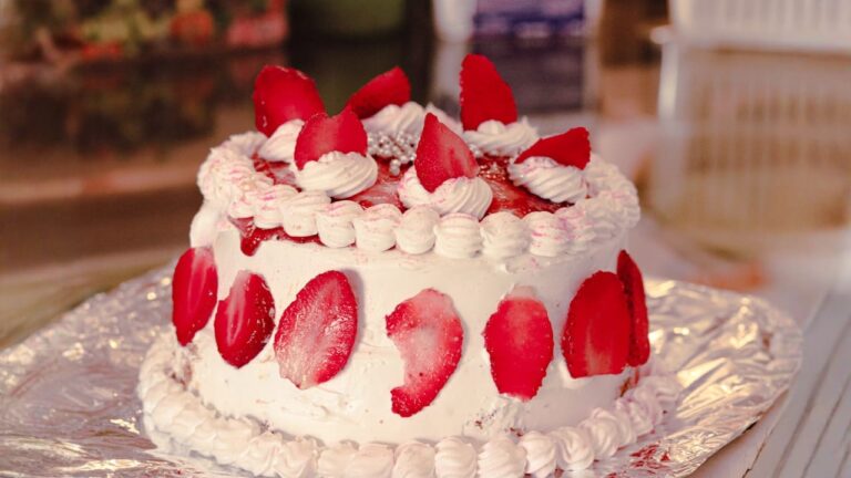white and red cake with strawberry on top