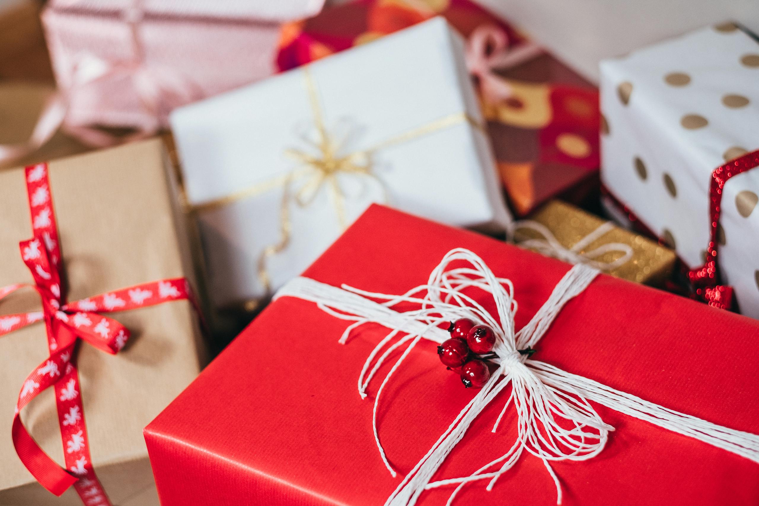 Close-up of festively wrapped Christmas gifts with ribbons and bows.