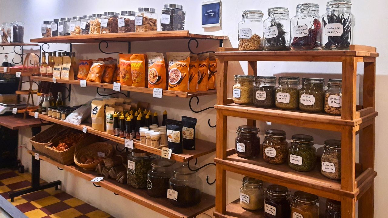Wooden shelves lined with labeled jars, spices, and packaged pantry goods.